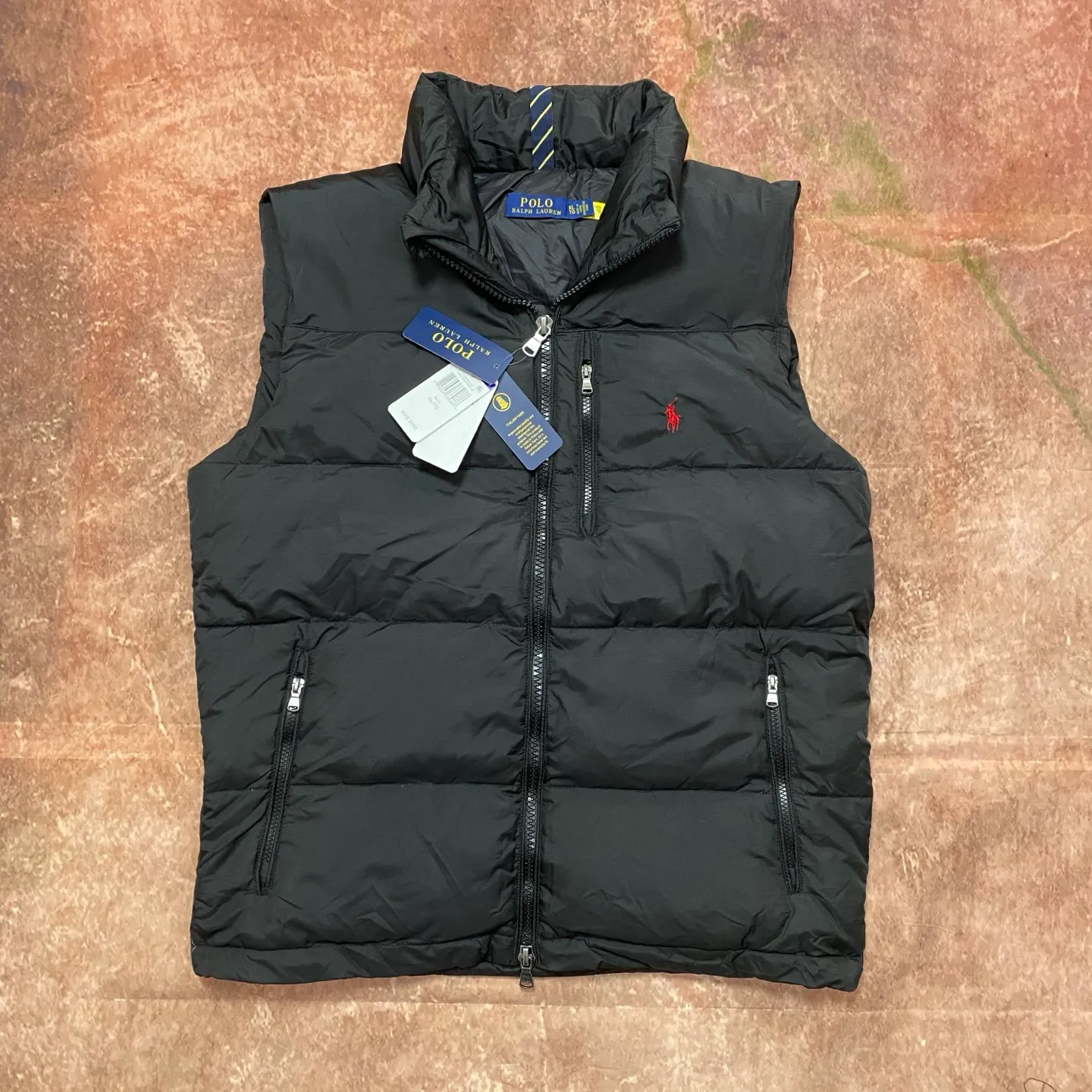 P560 Rah Lauren embroidered down vest (top version of pure down) 100% pure down, a classic and evergreen style, the same model used by celebrities and internet celebrities to keep out the cold, made from fabrics, fillings to auxiliary materials, all-round benchmarking against the original quality. It uses an imported Behringer embroidery machine, 10,000-needle electric embroidery technology, and imported No. 7 needles and embroidery thread to create a full, three-dimensional, clear-textured polo logo on the chest, which can be called a "moving texture badge." Double-layer locked velvet interior, bid farewell to the worry of velvet running away. The inner lining adopts a nylon double-layer sealed velvet structure to strictly prevent velvet drilling. The hem has a built-in adjustable drawstring, making it more windproof and cold-proof. Paired with customized size 8 YKK zipper, a must-have item for autumn and winter. Color Black, Navy Blue, Black Glossy Size m-xxl